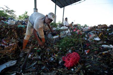 BALI, INDONESIA  APRIL 11: Poor from Java island working in a scavenging at the dump on April 11, 2012 on Bali, Indonesia. Bali daily produced 10,000 cubic meters of waste.